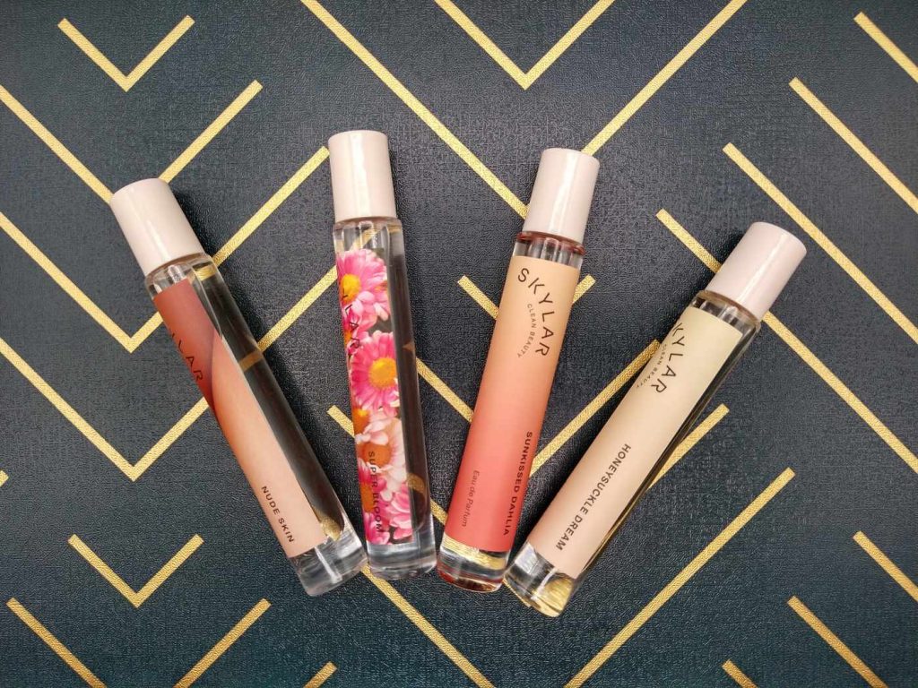 4 Perfume Rollers on a Green Background