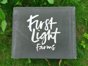 First Light Farms box sitting on grass